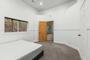 Carpeted bedroom featuring crown molding and a towering ceiling