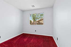 Spare room featuring carpet floors and baseboards
