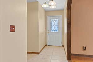 Entryway with tile patterned floors and a chandelier