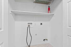Laundry room with gas dryer hookup, hookup for a washing machine, hookup for an electric dryer, and light tile patterned floors