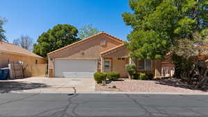 Mediterranean / spanish-style home featuring a tiled roof, stucco siding, concrete driveway, and an attached garage