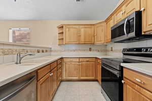 Kitchen featuring appliances with stainless steel finishes, backsplash, a textured ceiling, light tile patterned floors, and open shelves