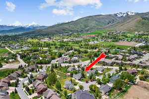 Aerial view of property and surrounding area with mountains and nearby suburban area
