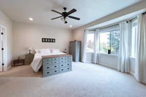 Bedroom featuring light carpet, a ceiling fan, recessed lighting, and a textured ceiling