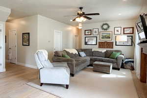 Living room with light wood finished floors and a ceiling fan