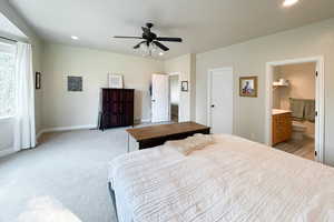 Bedroom with recessed lighting, light colored carpet, a ceiling fan, and connected bathroom