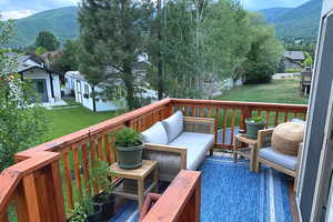 Wooden terrace with a lawn, a mountain view, and an outdoor hangout area