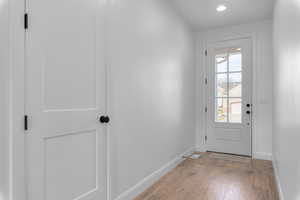Doorway to outside featuring wood-type flooring and recessed lighting