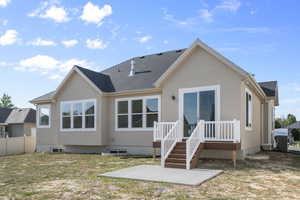 Rear view of house featuring a shingled roof and stucco siding