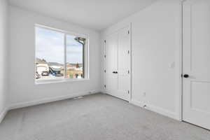 Unfurnished bedroom featuring carpet and a closet