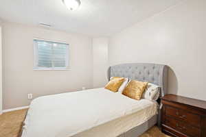 Bedroom with carpet and a textured ceiling