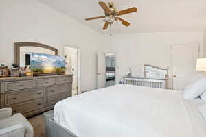 Carpeted bedroom with lofted ceiling and a ceiling fan
