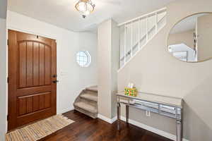 Foyer with stairway and dark wood-type flooring