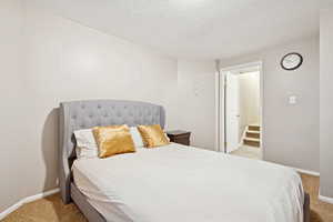 Bedroom with light carpet and a textured ceiling