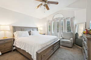 Bedroom with vaulted ceiling, light colored carpet, and a ceiling fan