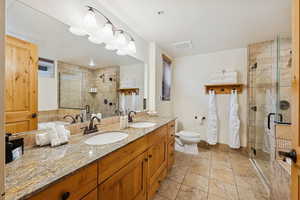 Bathroom featuring double vanity and a stall shower