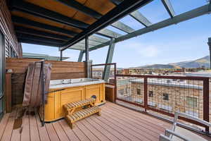 Wooden deck featuring a hot tub and a mountain view