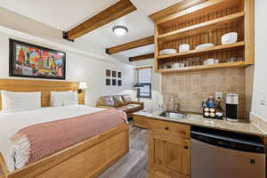 Bedroom with beamed ceiling and a sink