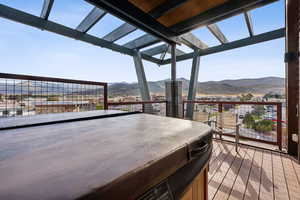 Wooden deck with a mountain view and a hot tub