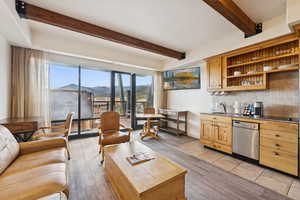 Living room featuring beam ceiling, a mountain view, and light tile patterned floors