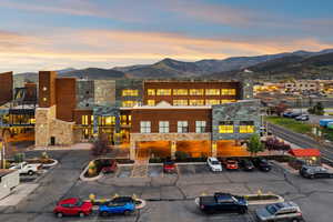 Property at dusk featuring a mountain view and uncovered parking