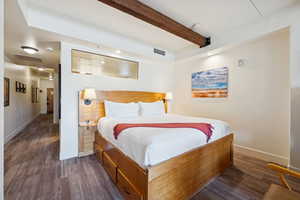 Bedroom with beam ceiling and attic access