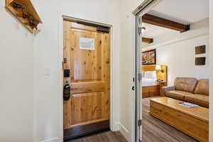 Doorway to outside featuring wood finished floors, beamed ceiling, and a sauna