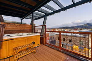 Deck featuring a hot tub and a mountain view