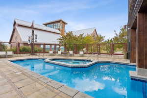 Community pool with a patio area and a community hot tub