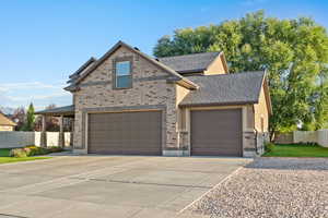 French country home with driveway, brick siding, and a garage