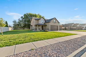 Traditional home featuring a garage, stone siding, driveway, covered porch, and brick siding