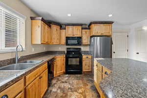 Kitchen with black appliances, recessed lighting, dark stone counters, and dark stone finish floors
