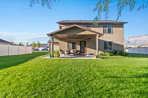 Back of house featuring stucco siding, a patio, and a mountain view
