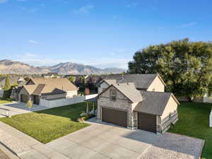 View of front facade featuring driveway, a mountain view, brick siding, a shingled roof, and a residential view