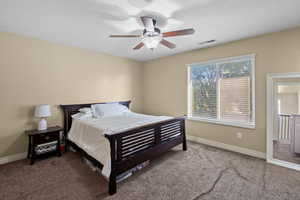 Carpeted bedroom with a textured ceiling and a ceiling fan