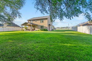 Rear view of property featuring a fenced backyard, a patio, and stucco siding