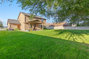 Back of property with a fenced backyard, a patio area, and stucco siding