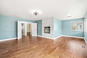 Unfurnished living room with a fireplace and wood finished floors
