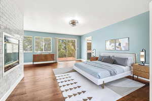 Bedroom featuring access to outside, wood finished floors, and ensuite bathroom