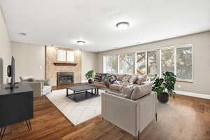 Living room with wood finished floors, a fireplace, and a textured ceiling