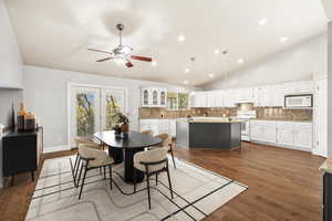 Dining space featuring dark wood-style floors, lofted ceiling, recessed lighting, and a ceiling fan