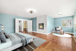 Bedroom with wood finished floors and a fireplace