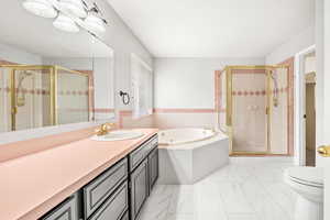 Full bath featuring vanity, a bath, a stall shower, and light marble finish floors