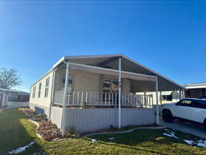 View of front of property featuring covered porch, a front lawn, and a carport