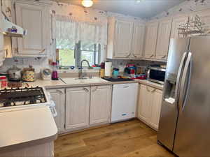 Kitchen with stainless steel appliances, light countertops, and light wood-style floors