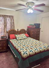 Bedroom featuring a ceiling fan and dark colored carpet