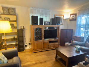 Living area featuring a textured ceiling and light wood-style floors