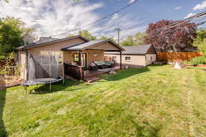 Back of house with outdoor lounge area, a patio area, a trampoline, and a garden