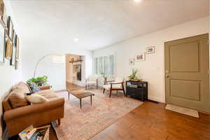 Living area featuring a textured ceiling and wood-type flooring