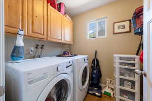 Washroom featuring washing machine and clothes dryer and cabinet space